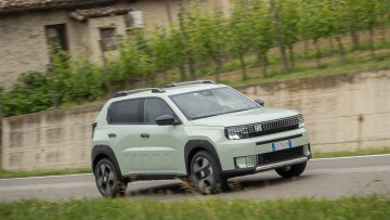 Fiat Grande Panda fahrend vor einer Steinmauer