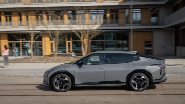 Kia EV4 Fastback fahrend vor Schule fotografiert