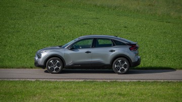 Citroen C4 You (2024) in der Seitenansicht auf Asphalt vor grüner Wiese im Sommer aufgenommen