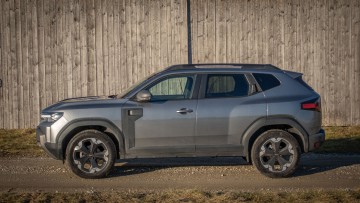 Dacia Duster in der Seitensicht stehend in der Nachmittagssonne abgelichtet. Dacia in grau lackiert