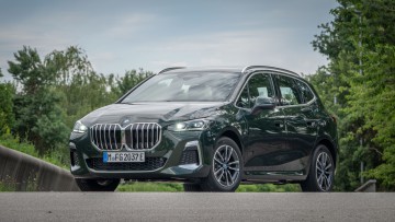 Foto des BMW 230e von vorn, der Plug-in-Hybrid ist in dunkelgrün lackiert.
