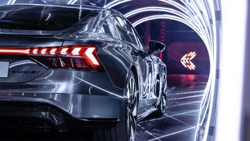 Ein Audi e-tron GT steht in einem Lichttunnel