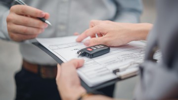 Unterschrift unter einem Kaufvertrag für ein Auto