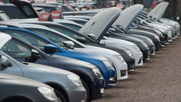 Neu- und Gebrauchtwagen stehen bei einem Autohändler in Dresden nebeneinander. 