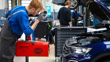 Ein Mechaniker bei der Einstellung der Fahrzeugbeleuchtung