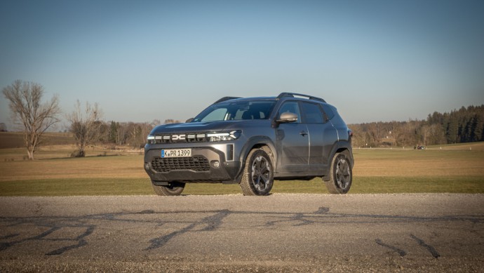 Dacia Duster 4x4 (2025) schräg von vorn in der Nachmittagssonne auf dem Land fotografiert