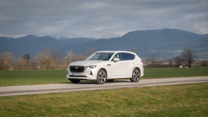 Mazda CX-60 D 254 AWD fahrend im Allgäu vor Bergen auf Asphalt