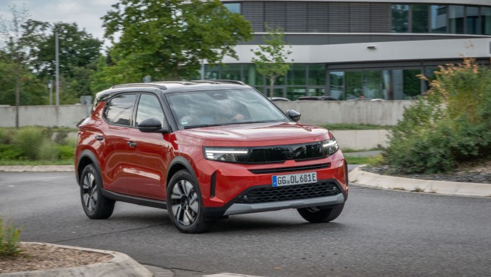Opel Frontera Electric (44 kWh) Opel Frontera Electric in der Standardlackierung Kanyon Orange Metallic fährt um Kreisverkehr