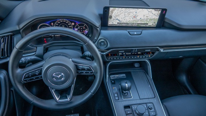 Foto vom gesamten Cockpit des Mazda CX-80 von oben durch das geöffnete Schiebedach aufgenommen.