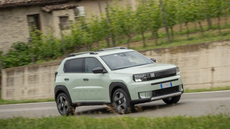 Fiat Grande Panda fahrend vor einer Steinmauer