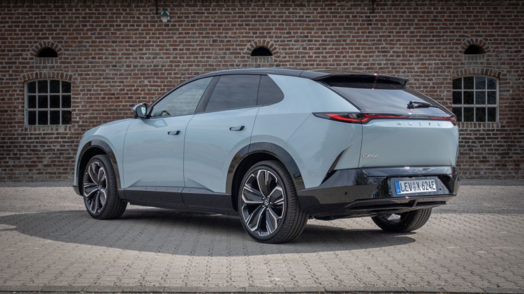Mazda CX-6e von hinten vor Ziegelwand fotografiert