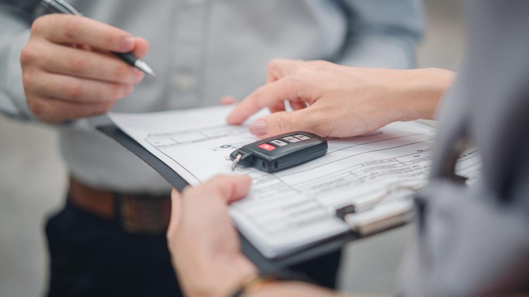 Unterschrift unter einem Kaufvertrag für ein Auto