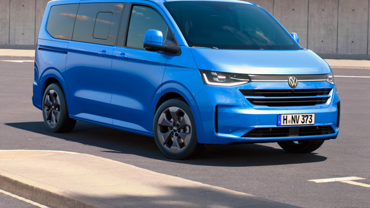 VW Caravelle (2025) in Mid Blue Metallic schräg von vorn in Nahaufnahme