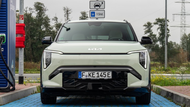 Ein Kia-Elektroauto steht auf einem Parkplatz an einer Ladestation