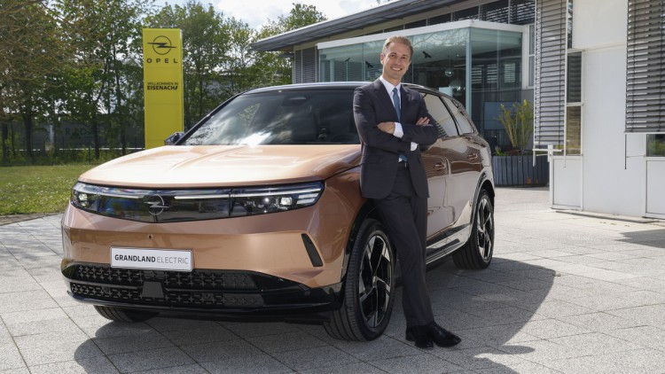 Opel Grandland (2024) mit angelehntem Opel Chef Florian Huettl im Werk Eisenach.