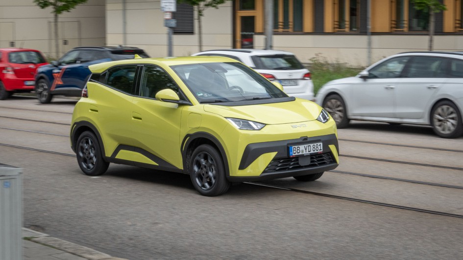 BYD Dolphin Surf in Lime Green fahrend auf einer Nebenstraße als Mitzieher fotografiert