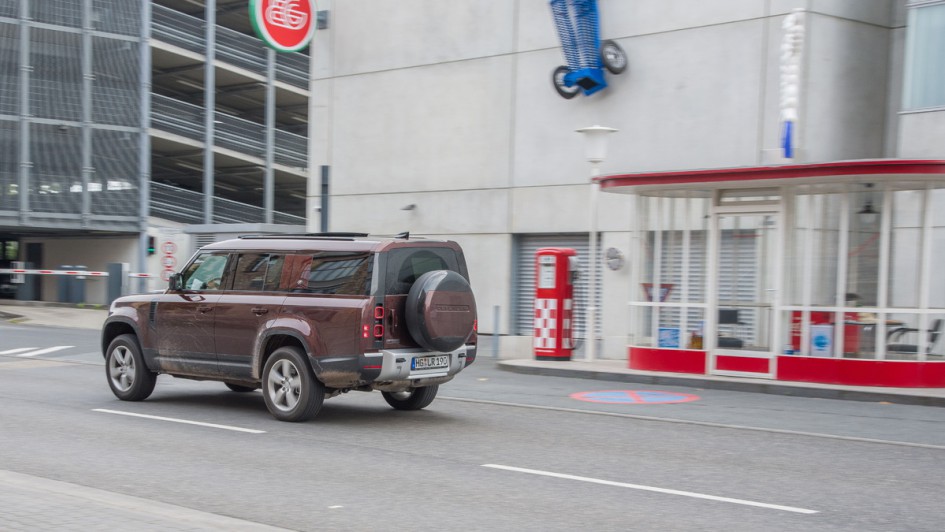 Land Rover Defender 130 fahrend von hinten fotografiert