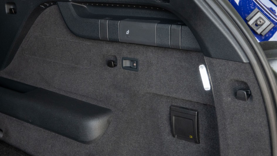 Schalter zur elektrischen Bedienung der Anhängekupplung in der rechten Kofferraum-Seitenwand