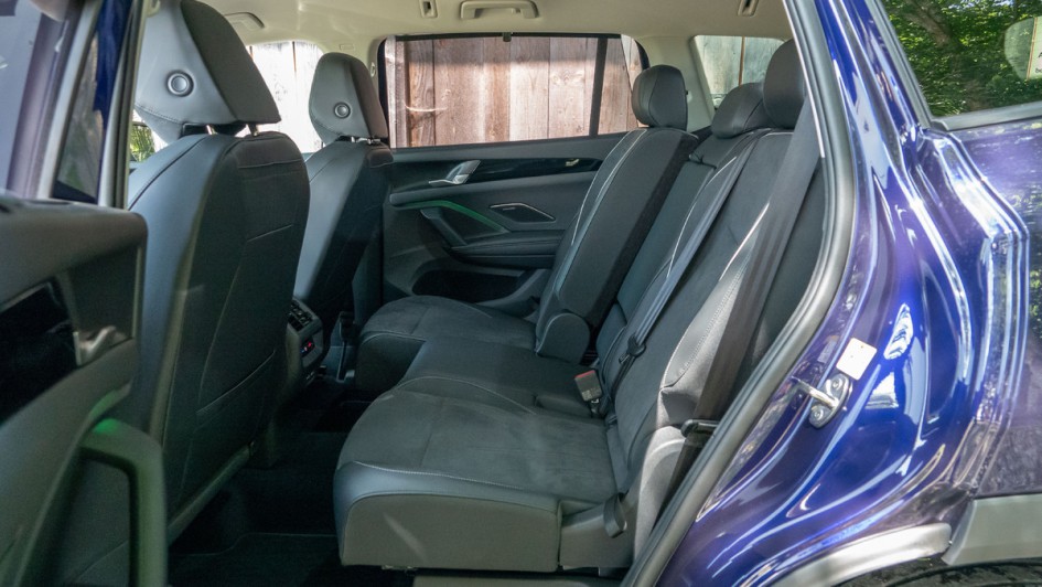 Mittlere Sitzreihe im VW Tayron, bei der der rechte teil, rund 40 Prozent der Rückbank, ein Stück nach vorn geschoben ist.