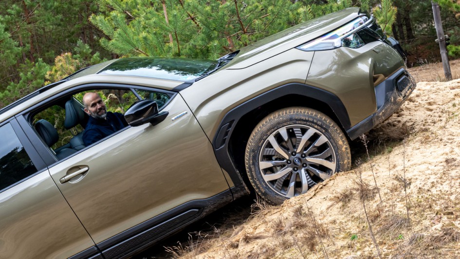 Subaru Forester 2025 auf einen Sandhügel gefahren, Fahrer grinst in die Kamera