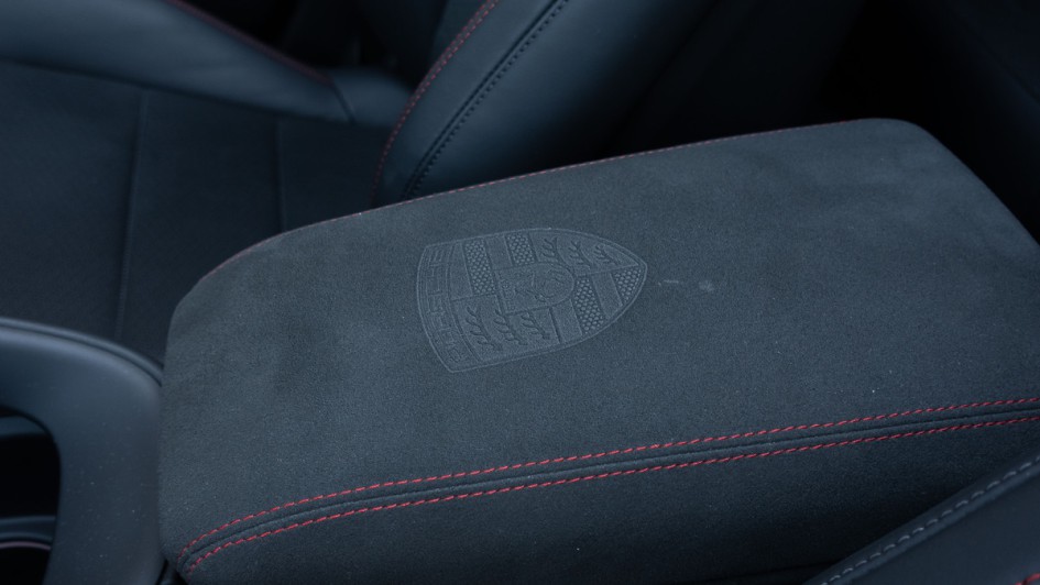 Porsche-Wappen auf der vorderen Mittelarmlehne, die mit Race-Tex bezogen ist