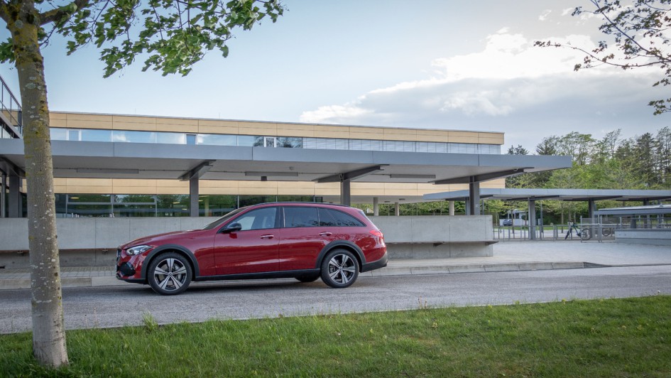 Mercedes C 220 d All Terrain in Patagonienrot stehend von der Seite vor Schule