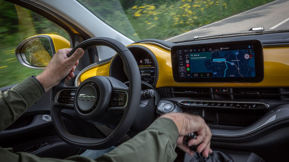 Aufnahme vom Armaturenbrett im neuen Fiat 500 Hybrid während der Fahrt mit Händen am Lenkrad