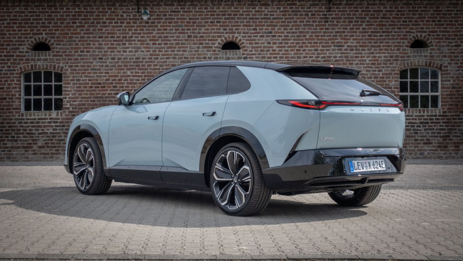 Mazda CX-6e von hinten vor Ziegelwand fotografiert