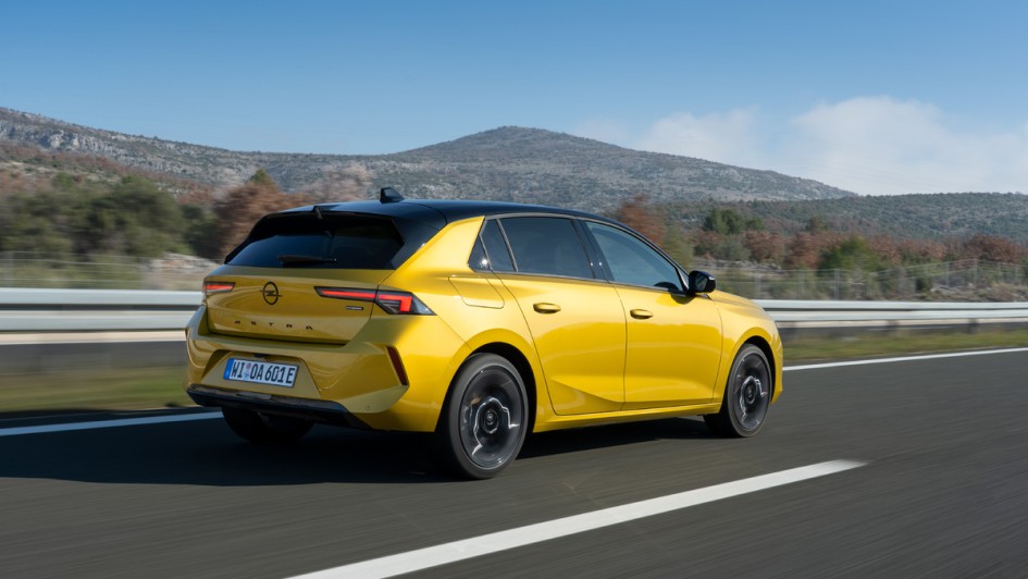 Opel AStra L fahrend von hinten aufgenommen, Astra ist in gelb lackiert.