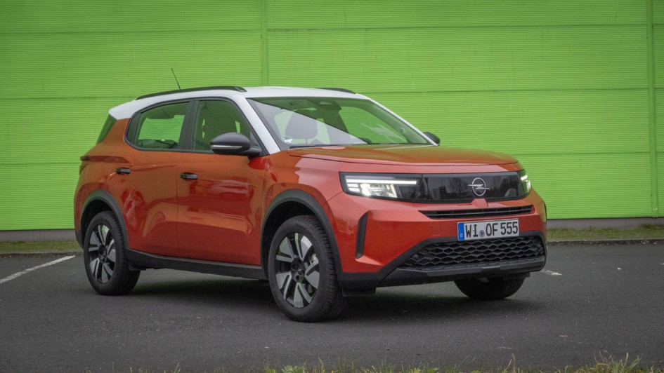 Orangefarbener Opel Frontera vor grüner Wand fotografiert