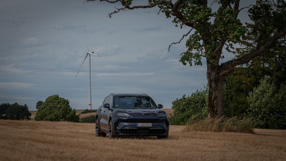 Cayenne Electric steht im Feld vor einem Windrad