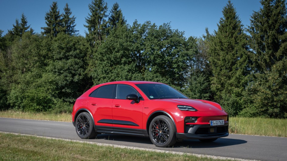 Porsche Macan GTS von schräg vorn stehend auf Asphalt vor Wiese und Wald fotografiert
