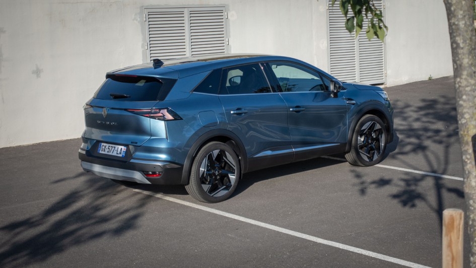 Renault Symbioz Foto schräg von hinten vor einer hellen Wand, Renault in einem kräftigen Metallic-Blau lackiert