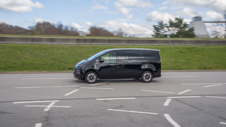 Hyundai Staria Signature AWD fahrend von der Seite vor Kläranlage an der Allianz-Arena