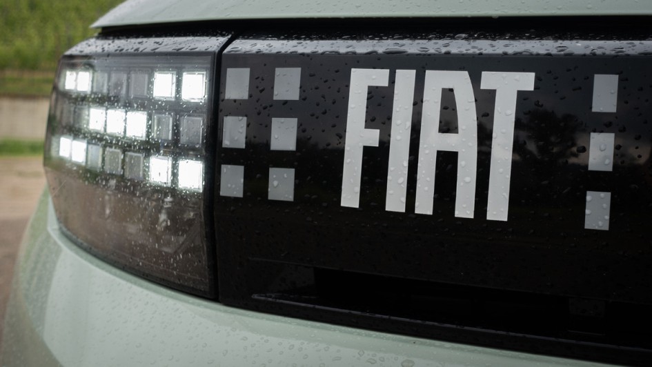 Detailfoto vom Kühlergrill des Fiat Grande Panda mit Schriftzug und eingeschaltetem Tagfahrlicht