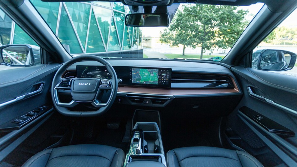Innenraumfoto mit der kompletten Ansicht des Armaturenbretts am KGM Musso EV mit dunkler Ausstattung